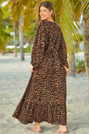 a woman standing on a beach wearing a leopard print dress