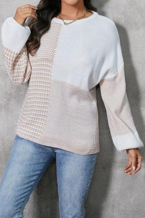 a woman posing for a picture wearing a sweater and jeans