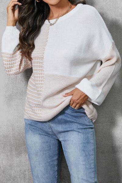 a woman wearing a white sweater and jeans