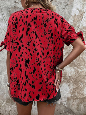 a woman wearing a red shirt with black spots