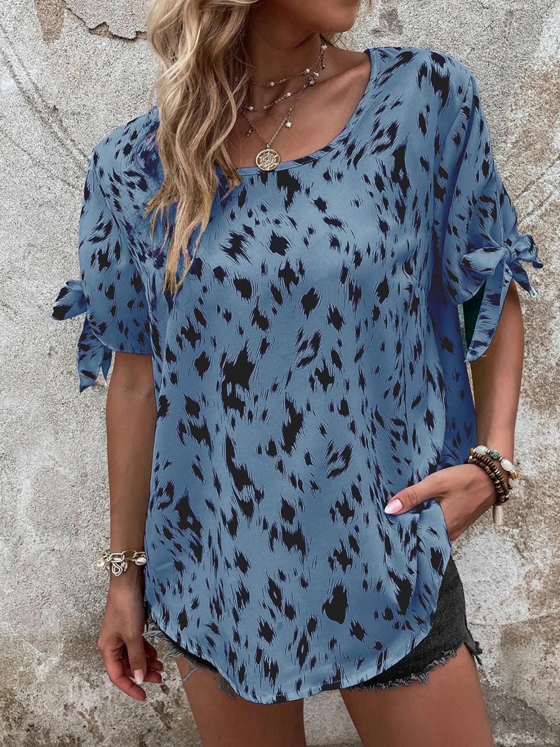 a woman wearing a blue top with black spots