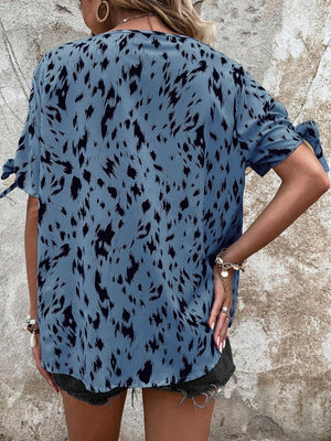 a woman wearing a blue top with black spots