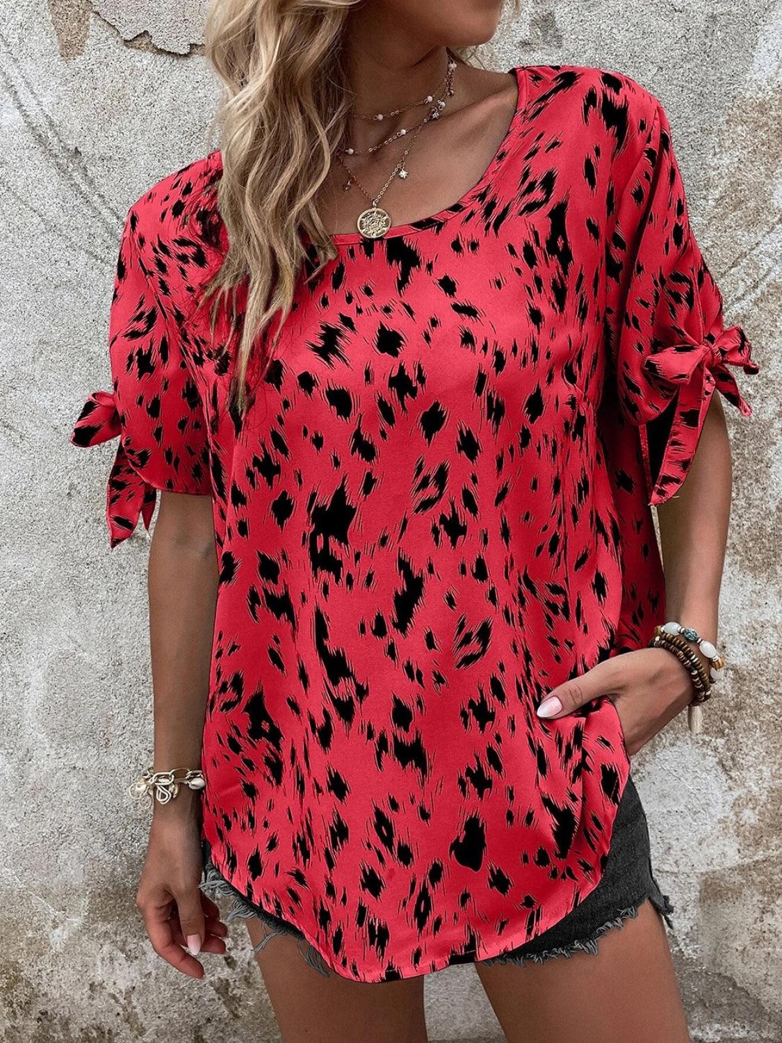 a woman wearing a red top with black spots