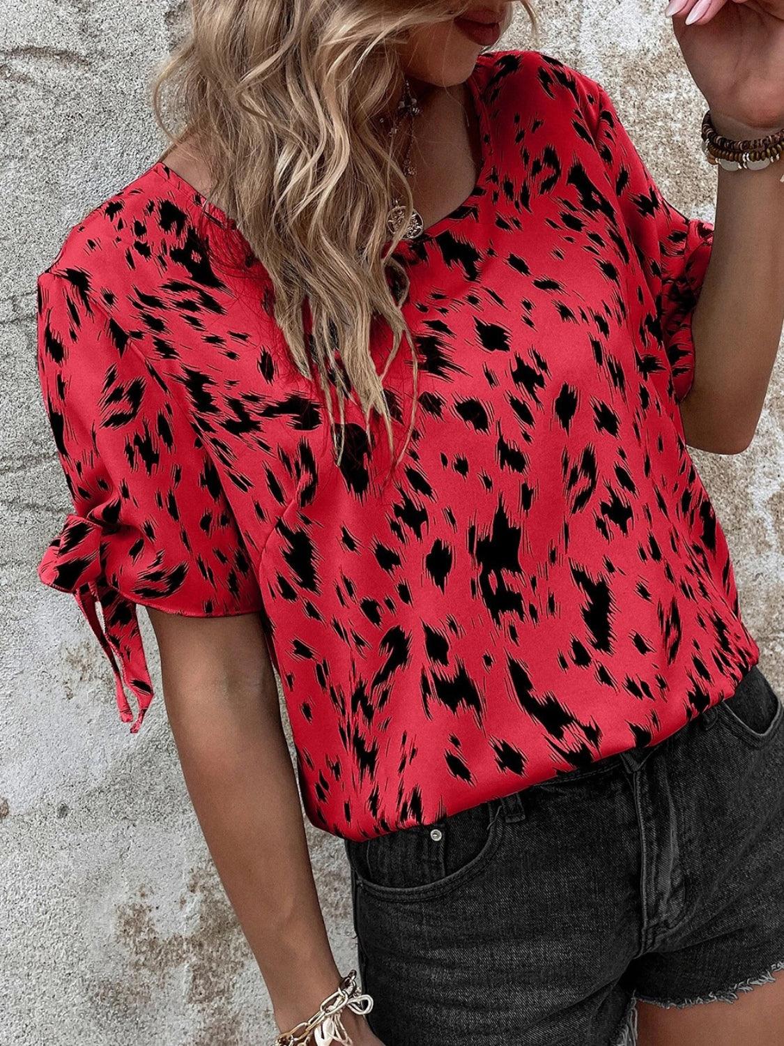 a woman wearing a red top with black spots