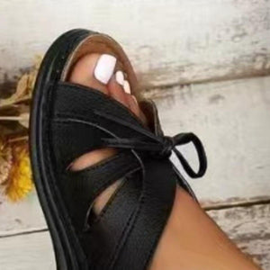 a close up of a person's foot wearing black sandals
