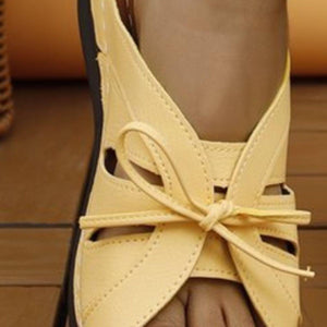 a close up of a person's foot wearing yellow sandals