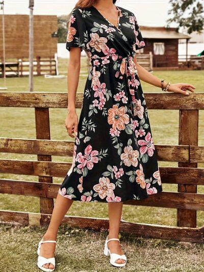 a woman standing next to a wooden fence