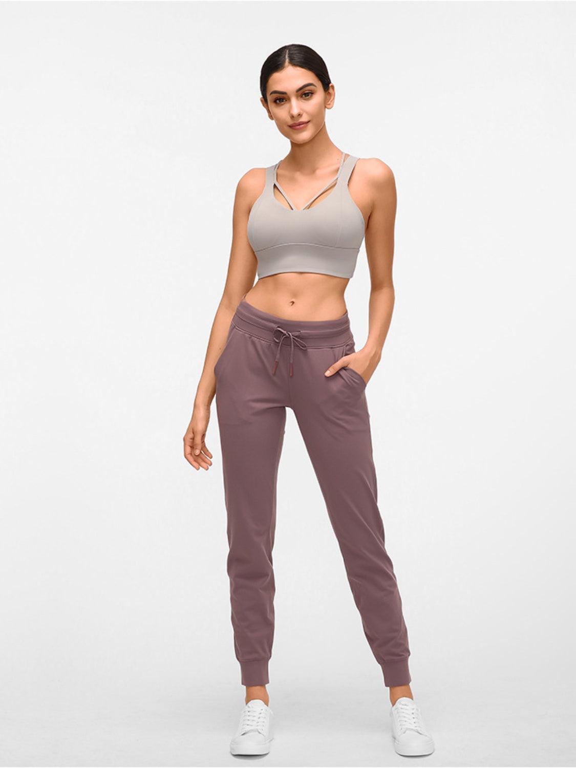 a woman in a sports bra top and sweat pants