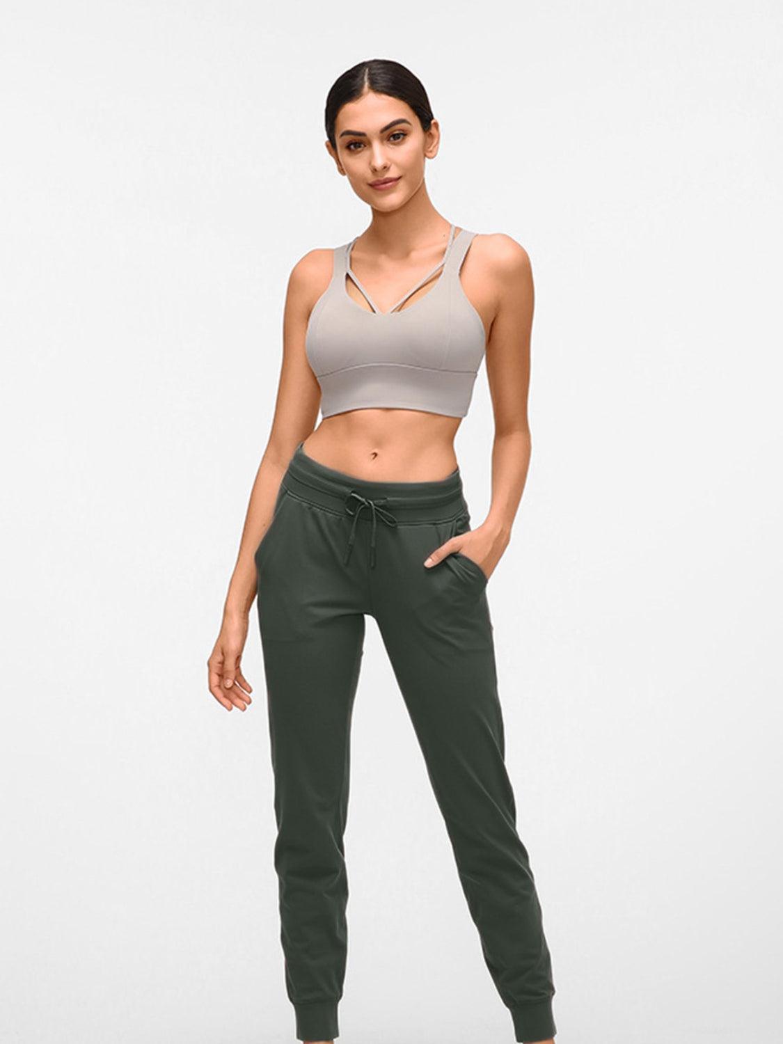 a woman in grey top and green pants