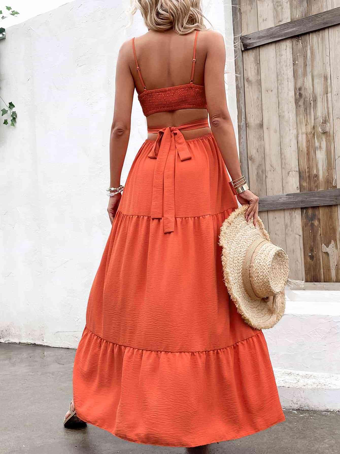 a woman in an orange dress and straw hat