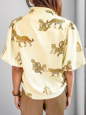 a woman wearing a yellow shirt with leopards on it