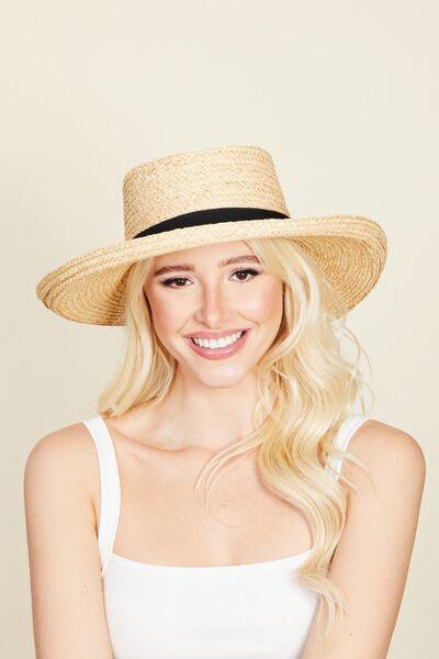 a woman in a white tank top and a straw hat