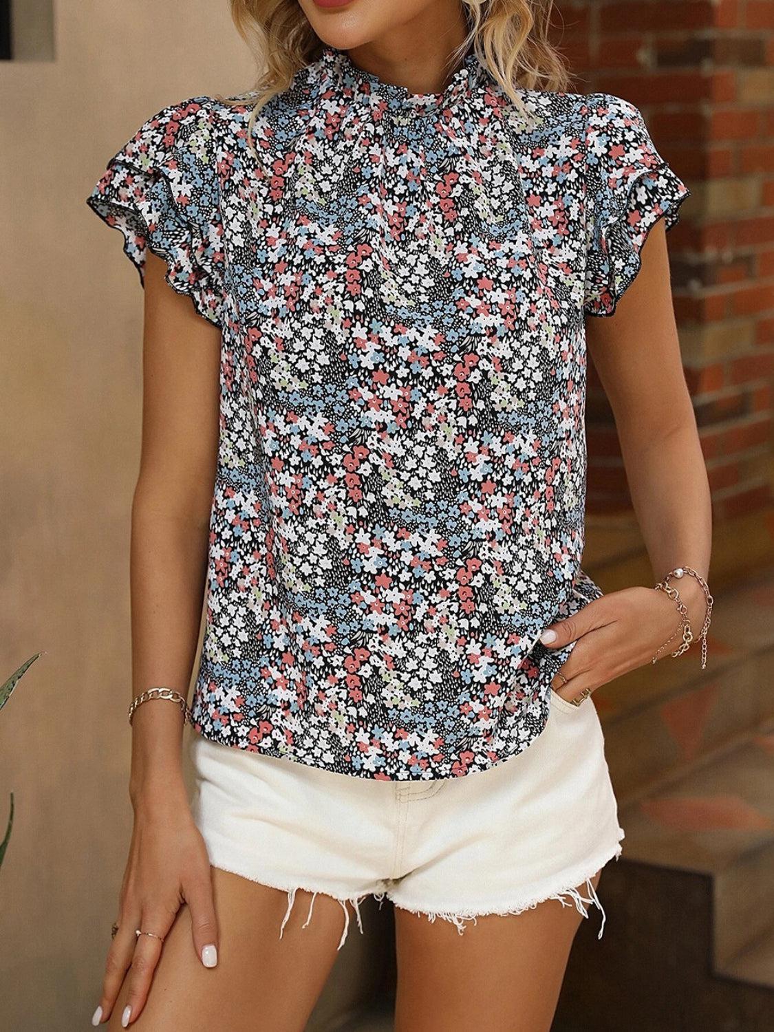 a woman in white shorts and a floral shirt