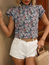 a woman wearing white shorts and a floral shirt