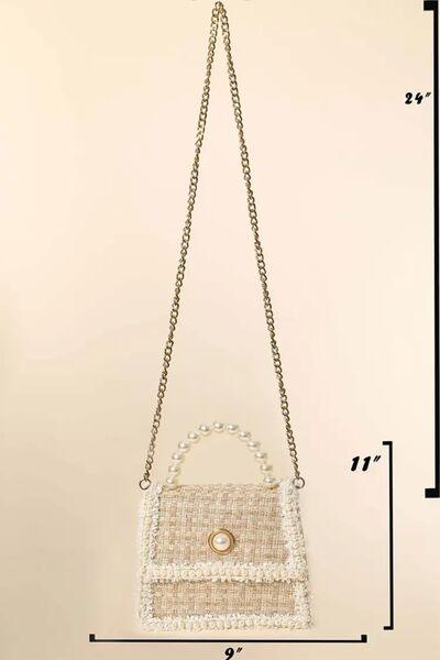 a white purse with a chain hanging from it