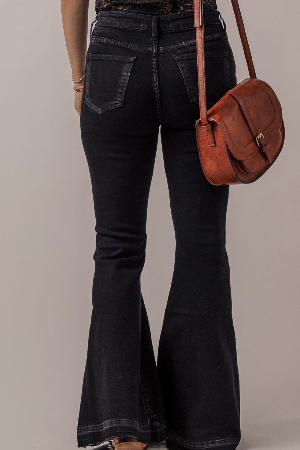 a woman in black jeans holding a brown purse