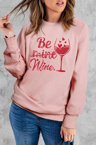 a woman wearing a pink sweatshirt with a wine glass on it