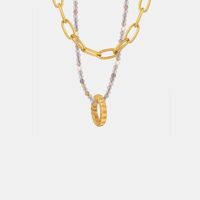 a necklace with a gold chain and a white beaded necklace