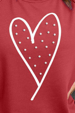 a woman wearing a red shirt with a heart drawn on it