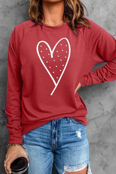a woman wearing a red sweatshirt with a heart on it