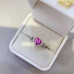 a pink heart shaped diamond ring in a white box