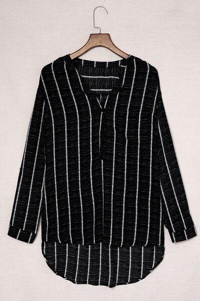 a black and white striped shirt hanging on a hanger