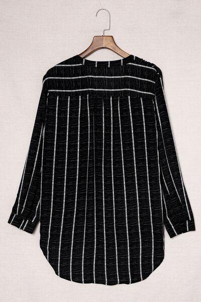 a black and white striped shirt hanging on a hanger