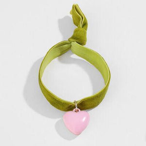 a pink heart hanging from a green cord