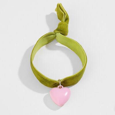 a pink heart hanging from a green cord
