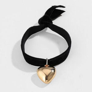 a black cord bracelet with a gold heart charm