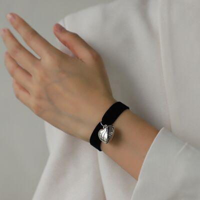 a close up of a person wearing a black bracelet