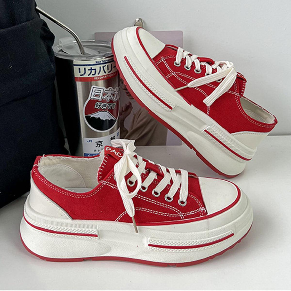 a pair of red and white shoes next to a can of soda