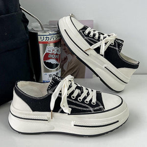 a pair of black and white shoes next to a can of soda