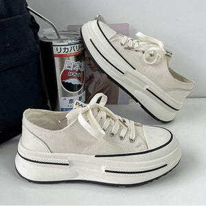 a pair of white shoes sitting next to a can of soda