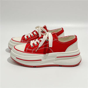 a pair of red and white shoes on a white surface