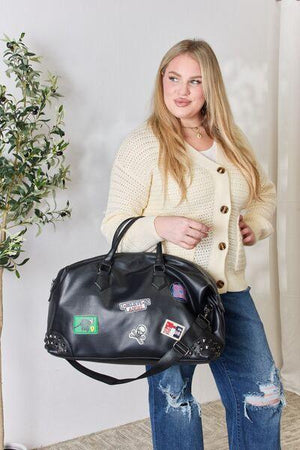 a woman is holding a black handbag