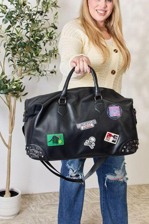 a woman holding a black bag with stickers on it