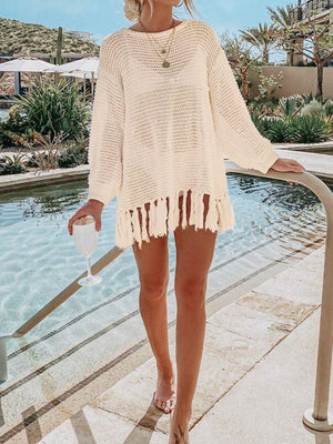 a woman in a white sweater and shorts standing next to a pool