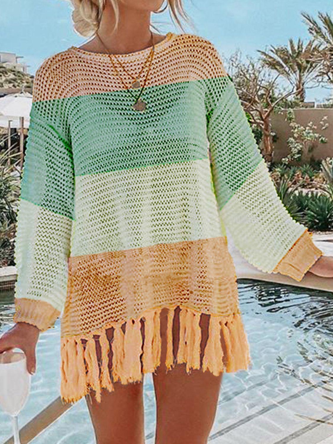 a woman standing next to a pool wearing a green and yellow sweater