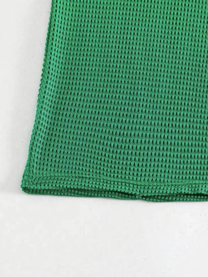 a close up of a green cloth on a white surface