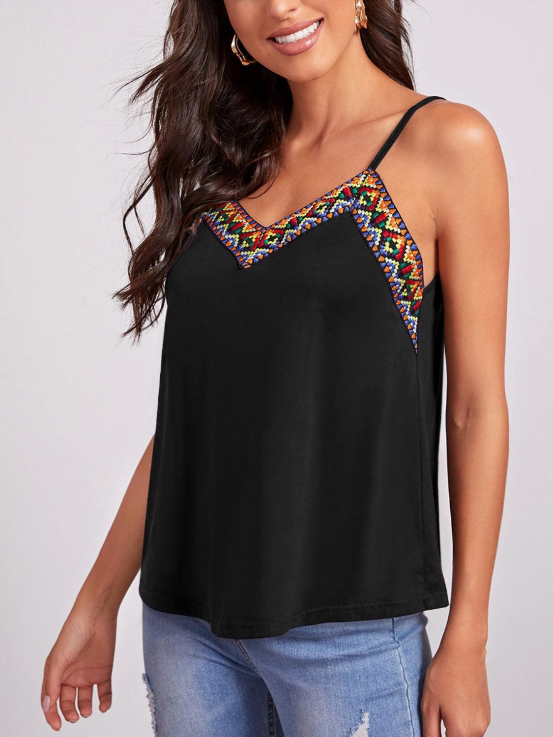 a woman wearing a black top with a colorful design
