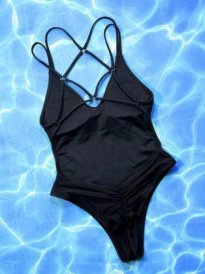 a black one piece swimsuit sitting on top of a blue pool