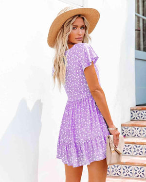 a woman wearing a purple dress and a straw hat