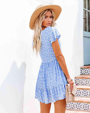 a woman wearing a blue dress and a straw hat