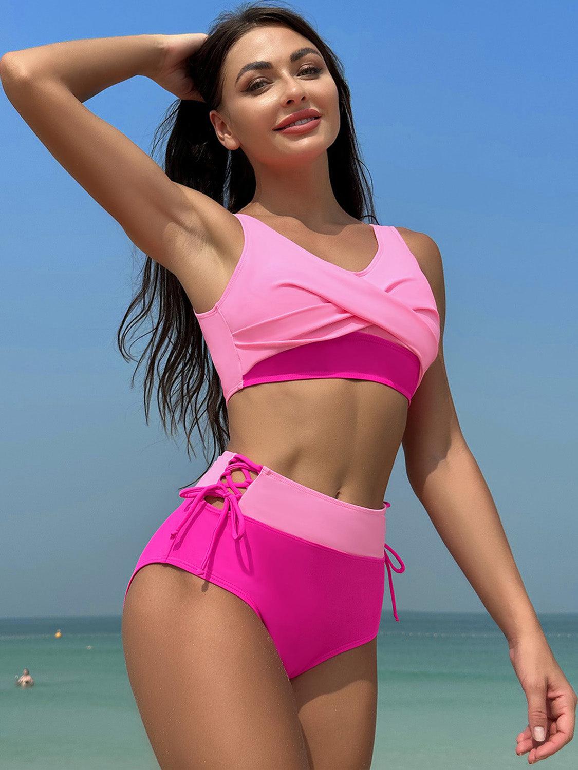 a woman in a pink swimsuit standing on the beach