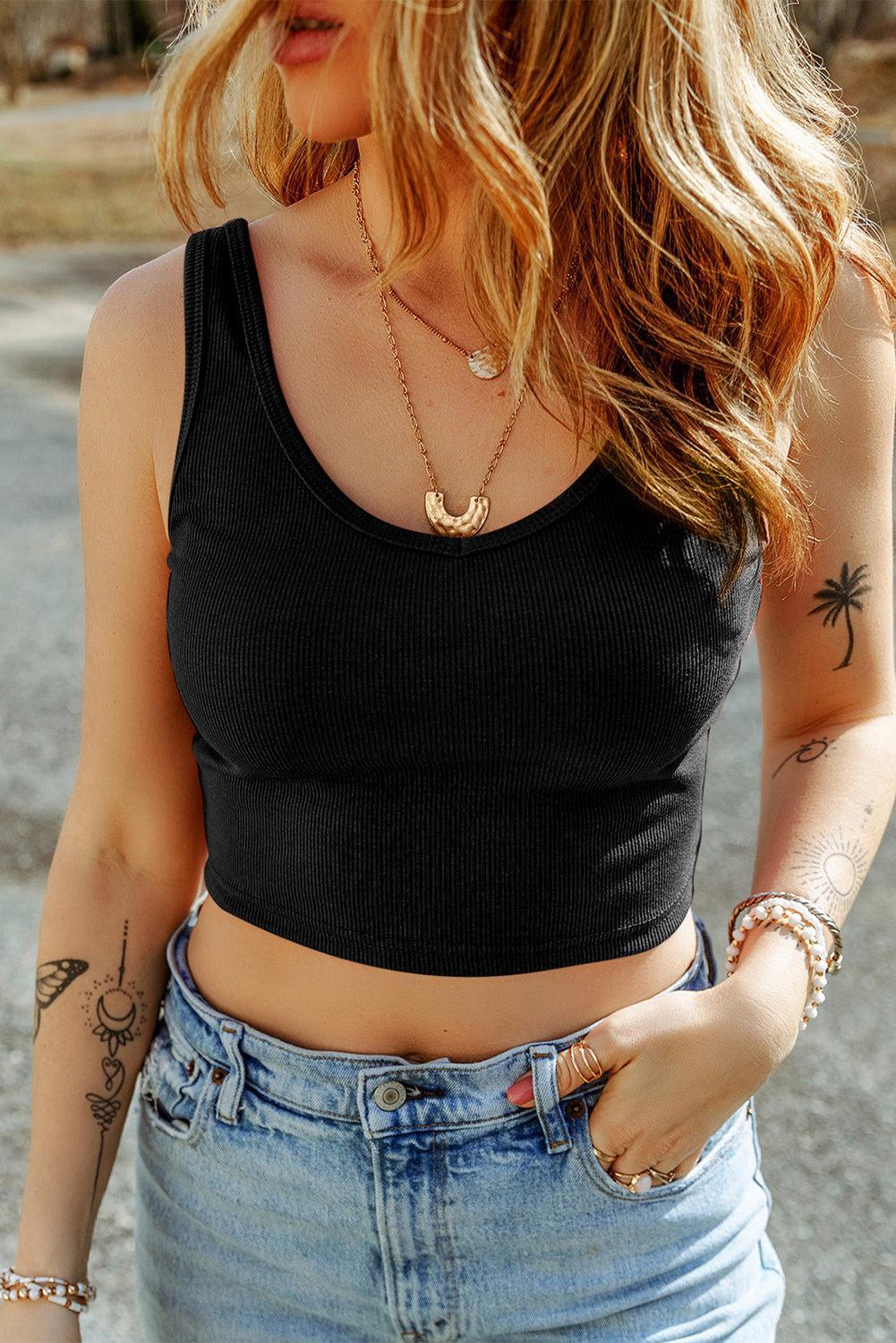 a woman wearing a black crop top and jeans