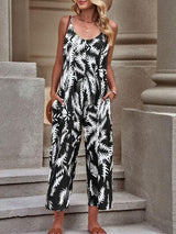 a woman wearing a black and white palm print jumpsuit