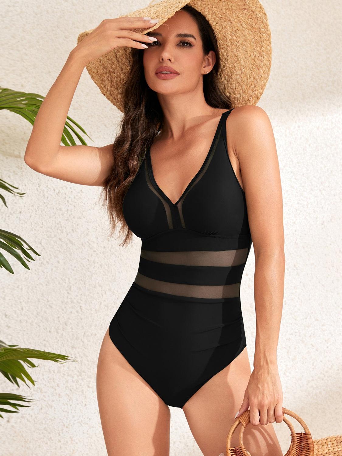 a woman in a black one piece swimsuit and straw hat