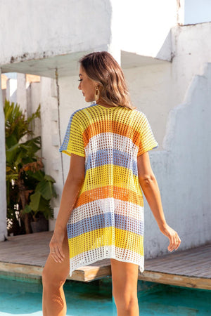 a woman in a yellow and blue striped dress standing next to a pool