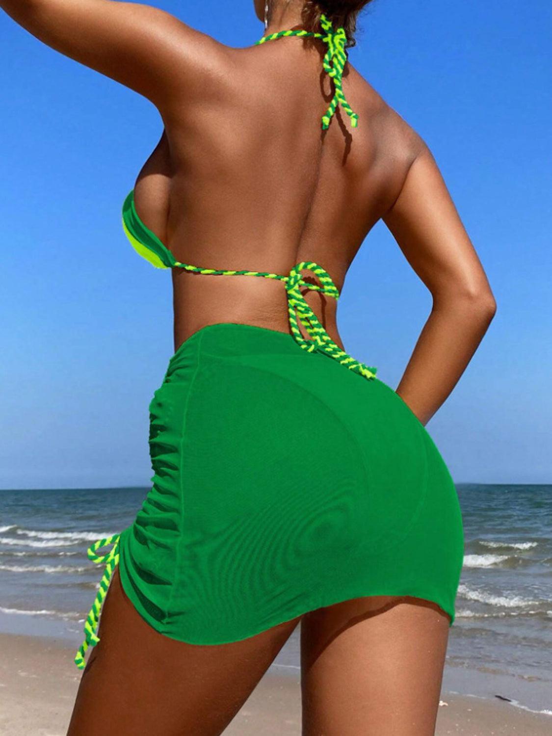 a woman in a green bikini on the beach